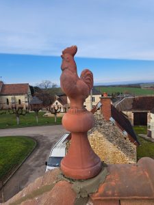 Epis coq en terre cuite posé sur un toit en tuile mécanique